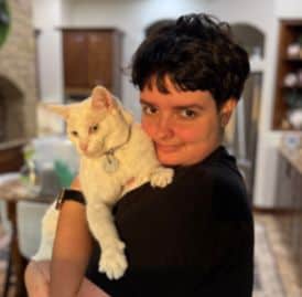 Young boy holding a white cat in a cozy home setting.